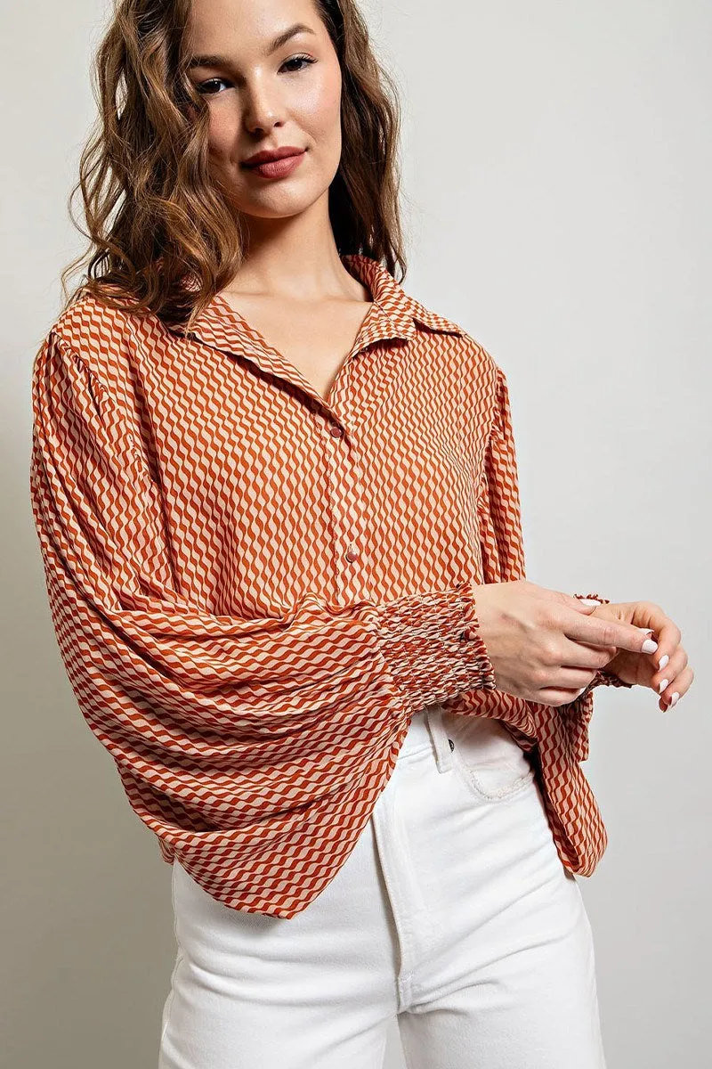 Printed blouse top with collared neckline, button down front, and smocked cuffs