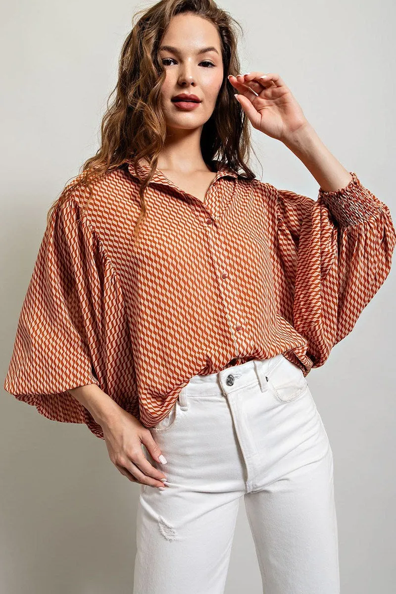 Printed blouse top with collared neckline, button down front, and smocked cuffs